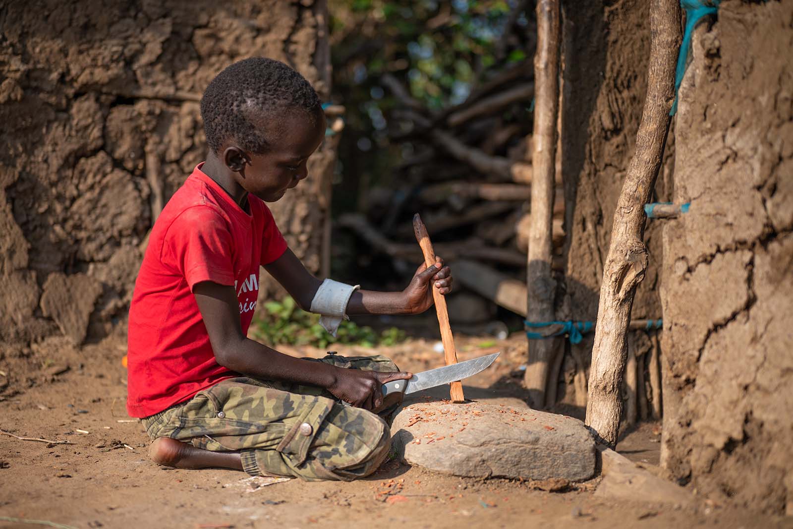 Kind schnitzt im Masai Village Kenia