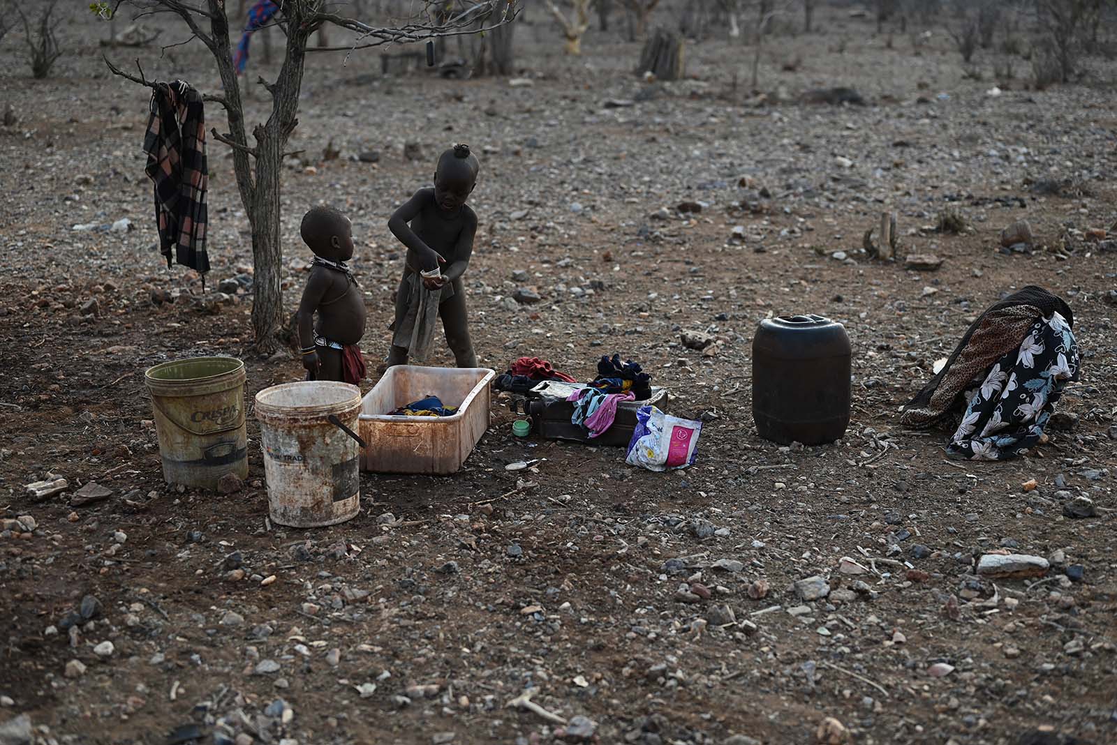 Zwei Himba Kinder waschen Wäsche