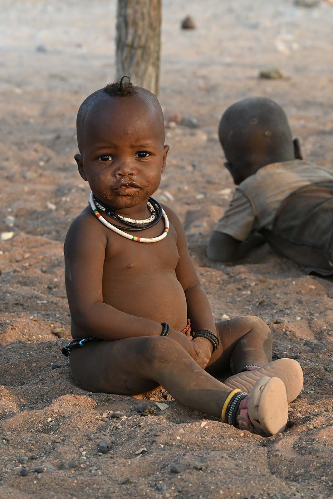 Portrait eines sitzenden Himba Kindes